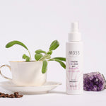 cmoss energizing face and mood mist next to amethyst tea cup and coffee beans