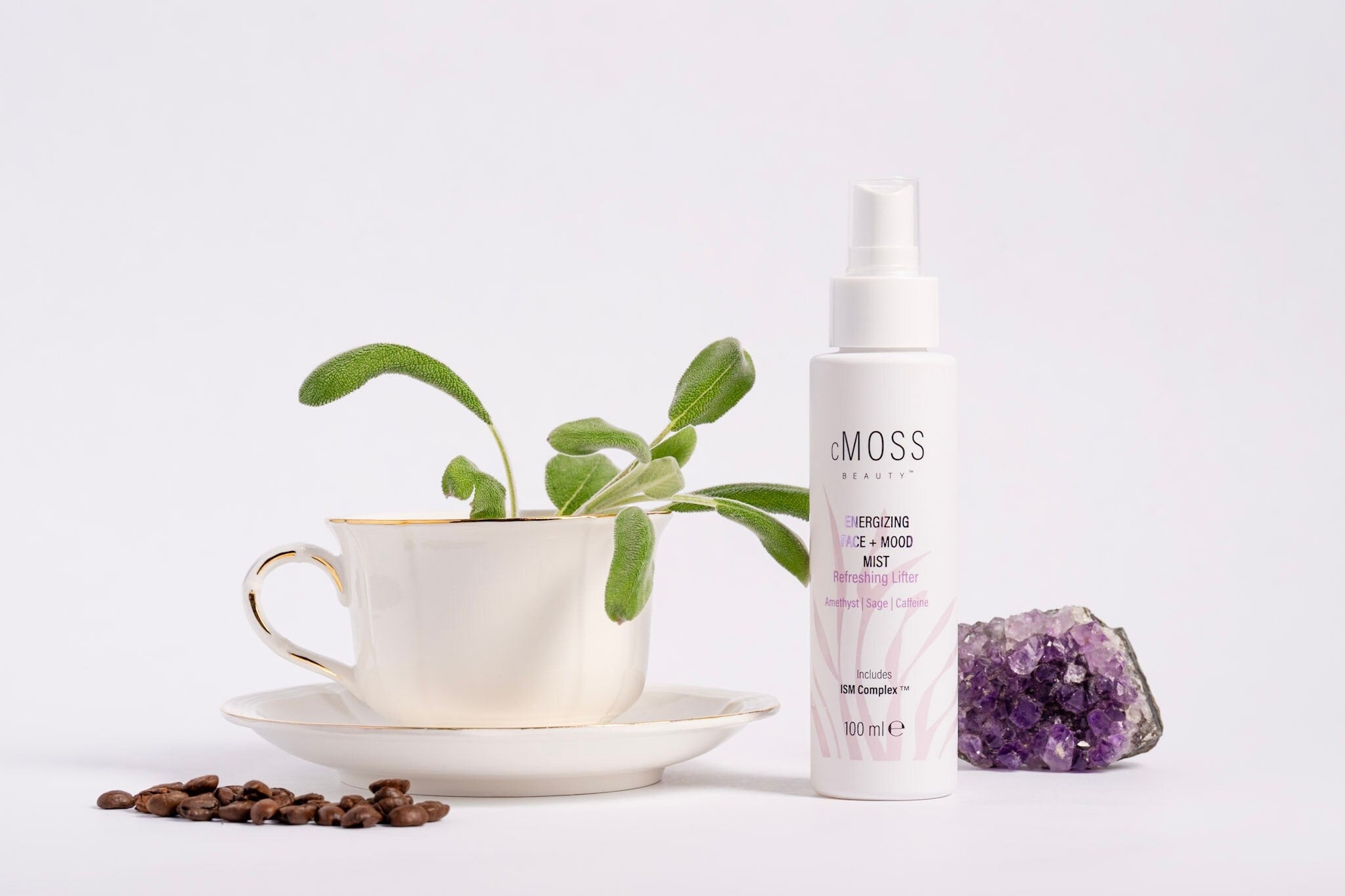 cmoss energizing face and mood mist next to amethyst tea cup and coffee beans